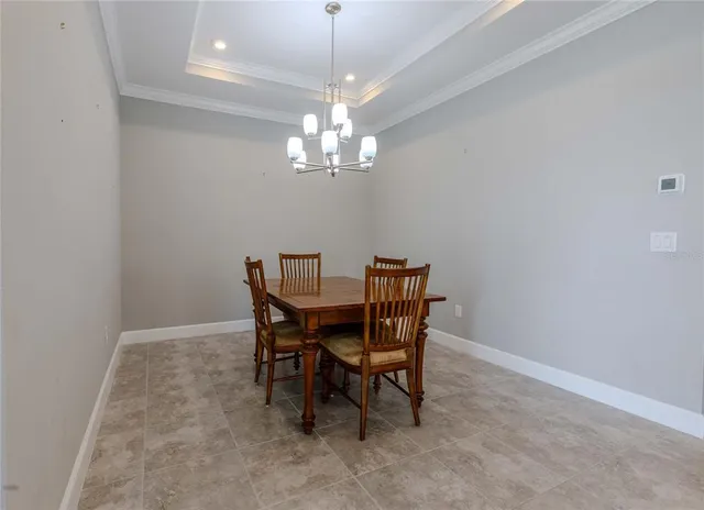 a view of a dining room with furniture and chandelier
