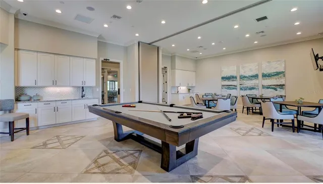 a kitchen with stainless steel appliances granite countertop a stove a sink dishwasher and white cabinets with wooden floor