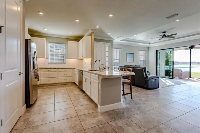 a kitchen with stainless steel appliances a sink a counter top space and living room view