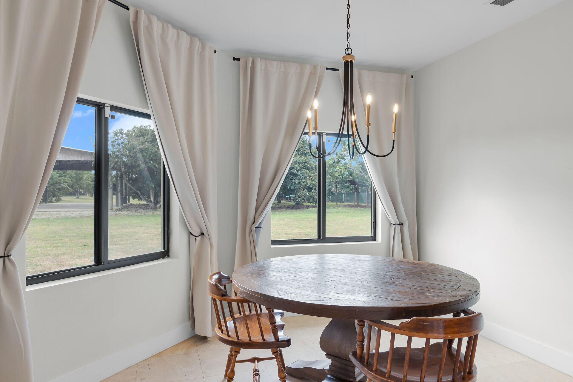 19900 Southwest 280th Street Homestead, FL 33031 - Photo 22 of 52 a view of a dining room with furniture wooden floor and a chandelier