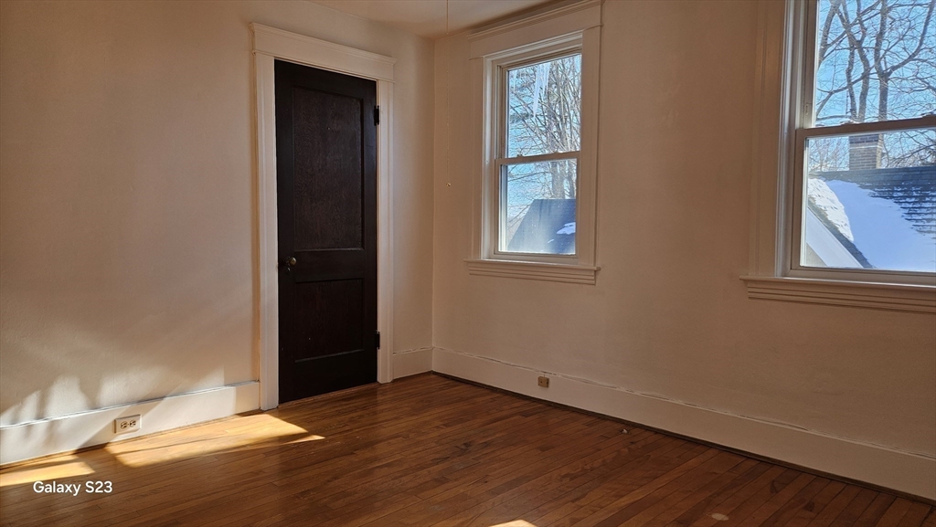 17 Cleveland Avenue, Unit 3 Worcester, MA 01603 - Photo 24 of 25 an empty room with wooden floor and windows