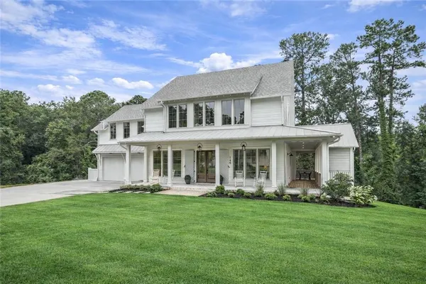 a front view of a house with garden and trees