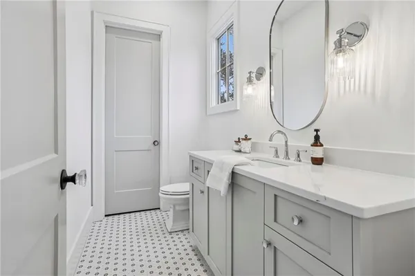a bathroom with a sink mirror vanity and toilet