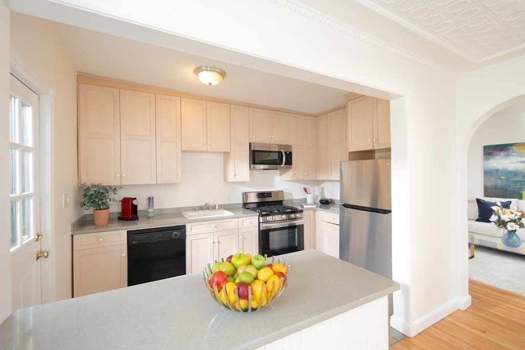 63 Reed Street, Unit 63 Cambridge, MA 02140 - Photo 3 of 16 a kitchen with stainless steel appliances a stove refrigerator sink and wooden floor
