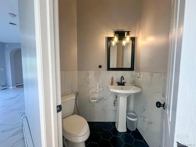a bathroom with a sink toilet and a mirror