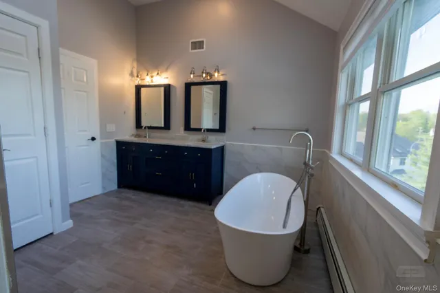 a bathroom with a granite countertop toilet sink and mirror