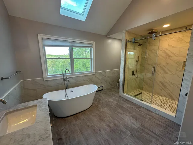 a spacious bathroom with a tub shower and window