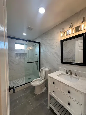 a bathroom with a sink toilet a mirror and shower