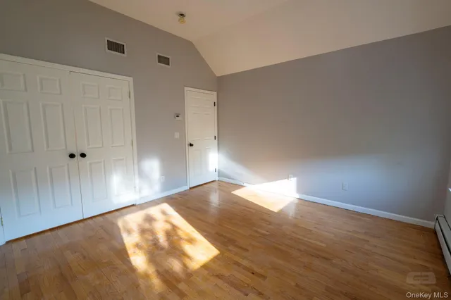 a view of empty room with wooden floor