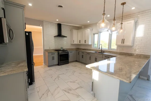 a kitchen with stainless steel appliances granite countertop a sink a stove and a refrigerator