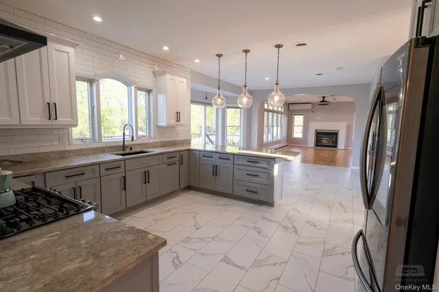 a large kitchen with stainless steel appliances granite countertop a stove a sink a refrigerator and a granite counter tops