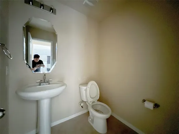 a bathroom with a toilet sink and mirror