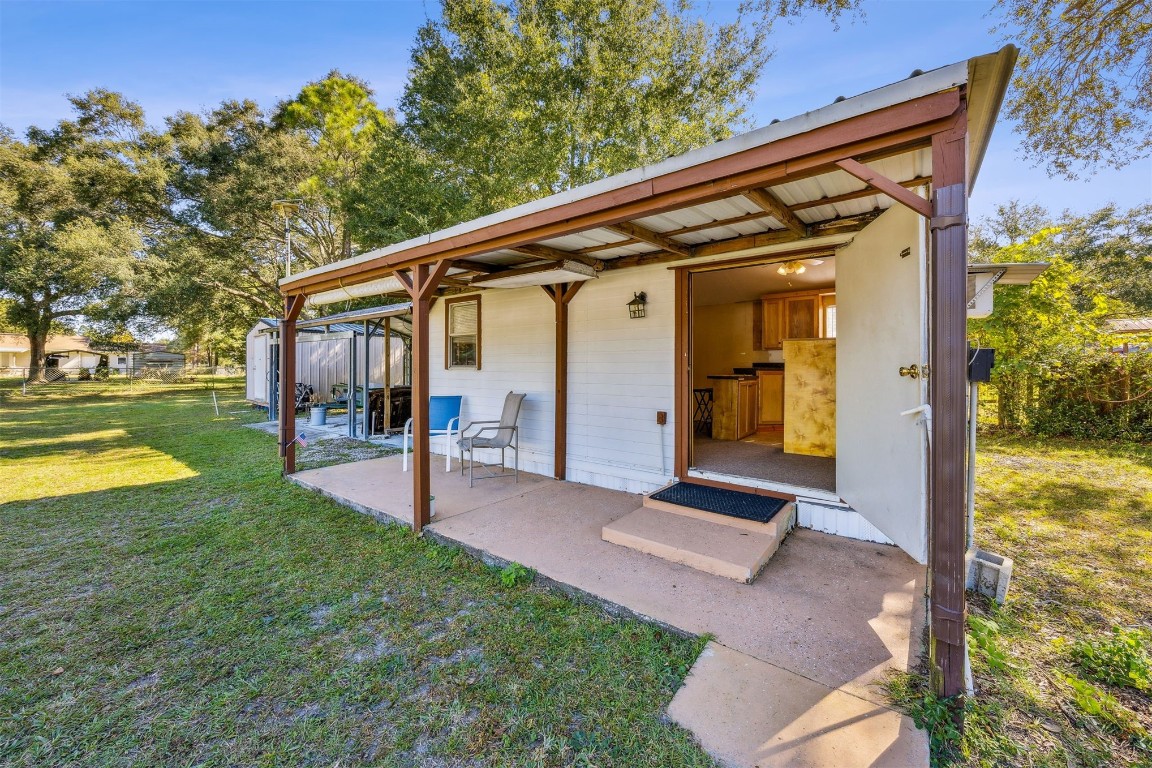 85256 Stephen Road Yulee, FL 32097 - Photo 32 of 40 a view of a patio with a table and chairs under an umbrella