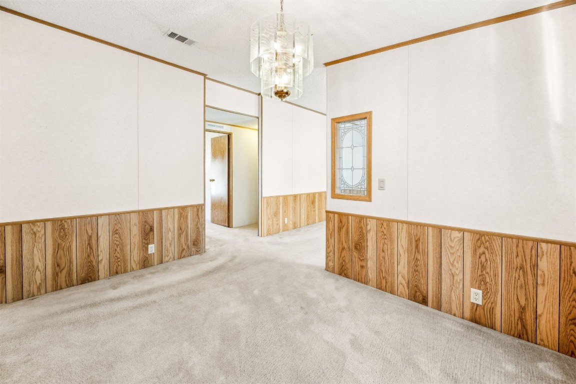 85256 Stephen Road Yulee, FL 32097 - Photo 8 of 40 a view of a hallway with wooden floor and chandelier