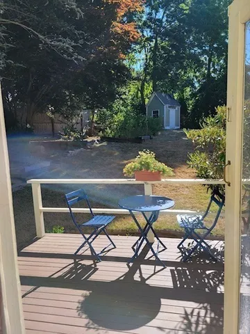 a view of swimming pool with lawn chairs and wooden fence