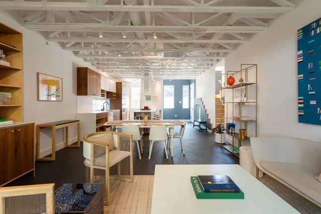 a living room with lots of furniture and kitchen view