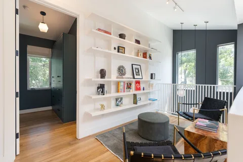 a view of a hallway with white cabinets and entryway