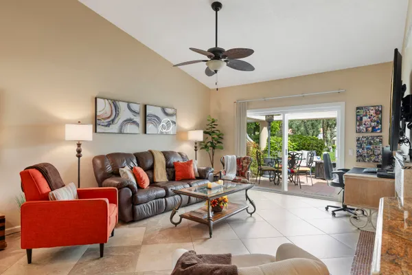 a living room with furniture ceiling fan and a large window