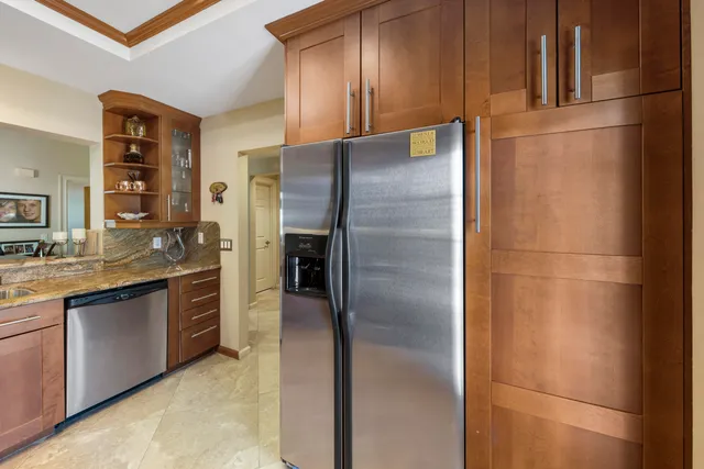 a kitchen with stainless steel appliances granite countertop a refrigerator and a sink