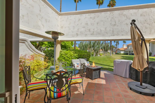 a view of a chairs and table in patio with a fire pit