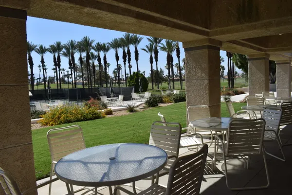 a view of a swimming pool and lounge chairs in back yard of the house