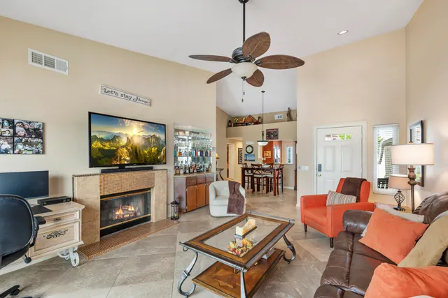 a living room with furniture a flat screen tv and a fireplace