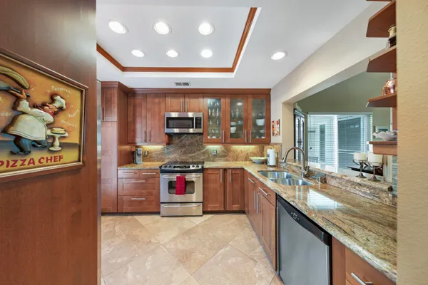 a kitchen with stainless steel appliances granite countertop a refrigerator and a sink