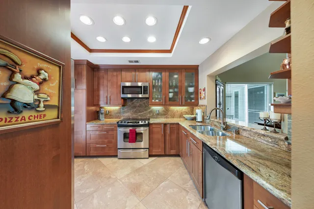 a large kitchen with stainless steel appliances granite countertop a stove and cabinets