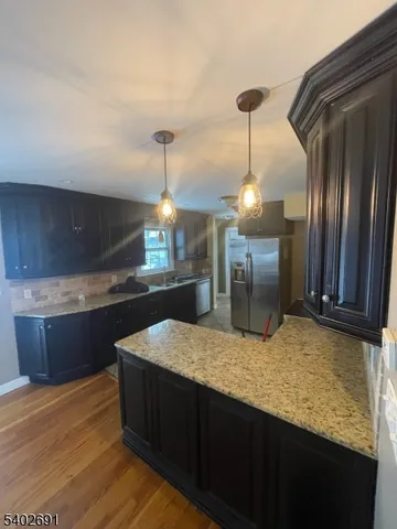 a kitchen with kitchen island sink and refrigerator