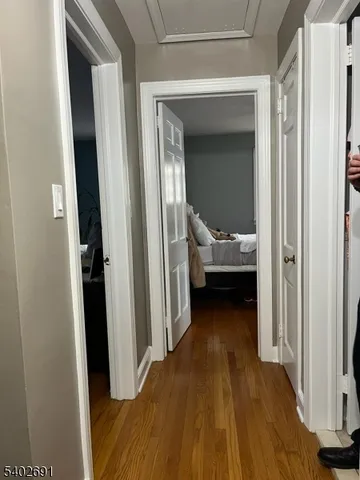 a view of a hallway with a bedroom and wooden floor