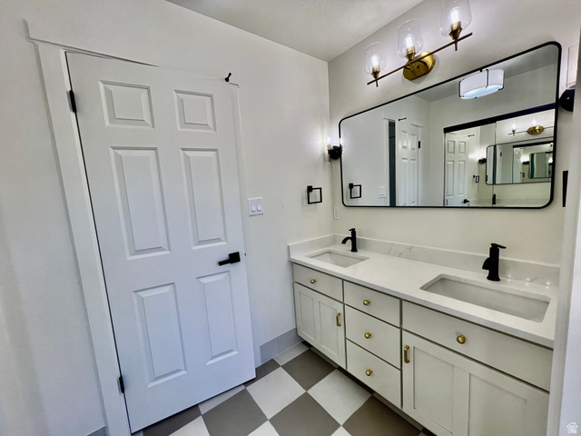 812 East Bates Cyn Road Tooele, UT 84074 - Photo 56 of 144 Double vanity featuring white cabinetry with gold-tone hardware, quartz countertops, and integrated rectangular sinks