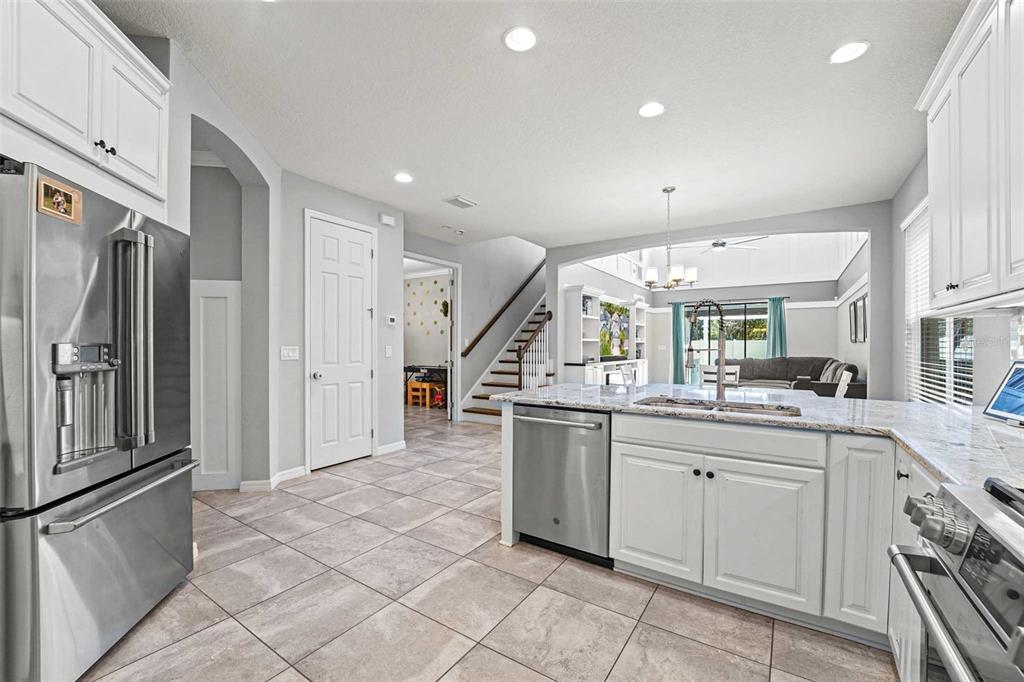 8903 Arabella Lane Seminole, FL 33777 - Photo 3 of 47 a kitchen with stainless steel appliances granite countertop a sink and a refrigerator