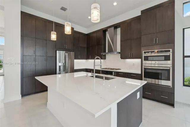 a kitchen with stainless steel appliances a refrigerator a sink a stove a microwave and island