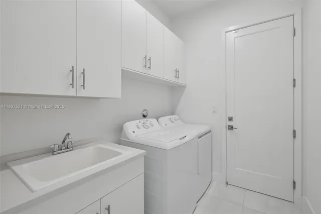 a utility room with sink dryer and washer