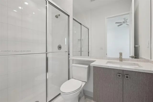a bathroom with a granite countertop sink toilet and shower