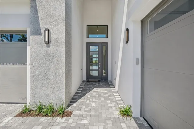 a view of a hallway with wooden floor and a bathroom