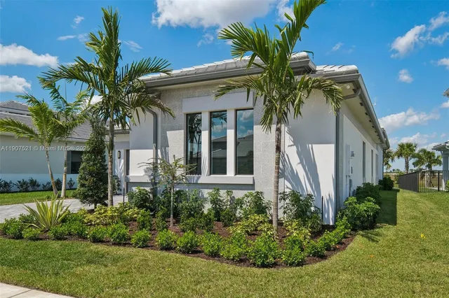 a view of a house with a yard and potted plants