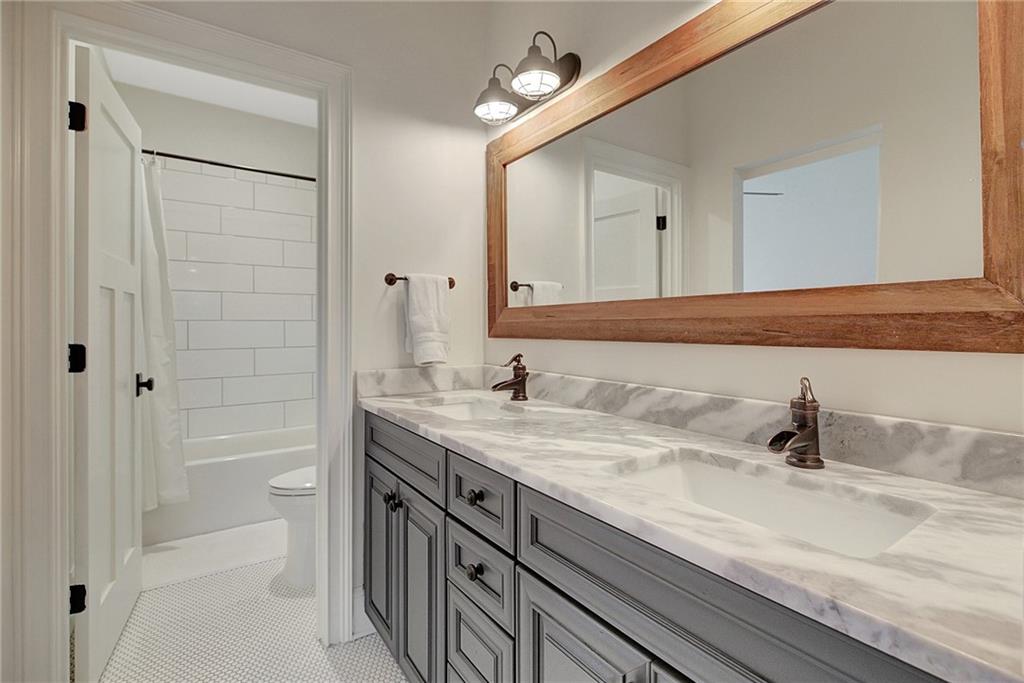 25 Paragon Point Newnan, GA 30265 - Photo 66 of 127 a bathroom with a granite countertop sink a mirror and a shower