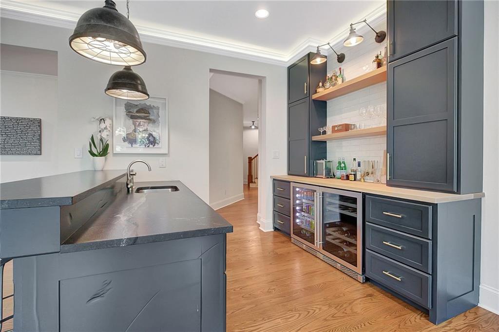25 Paragon Point Newnan, GA 30265 - Photo 83 of 127 a kitchen with stainless steel appliances granite countertop a sink dishwasher and cabinets with wooden floor