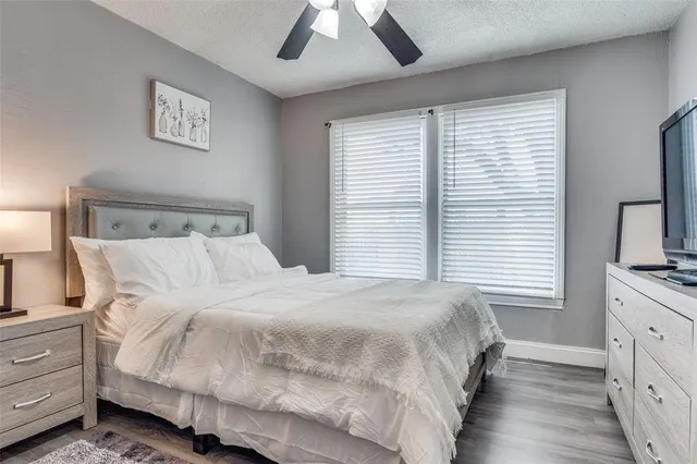 a bedroom with a bed and a flat tv screen on dresser