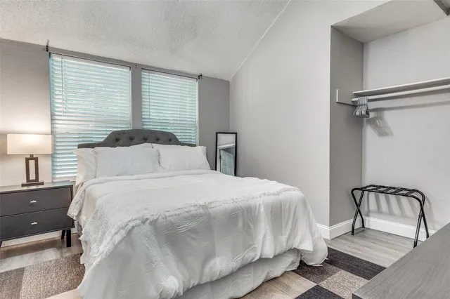 a bedroom with a bed a lamp and a large window