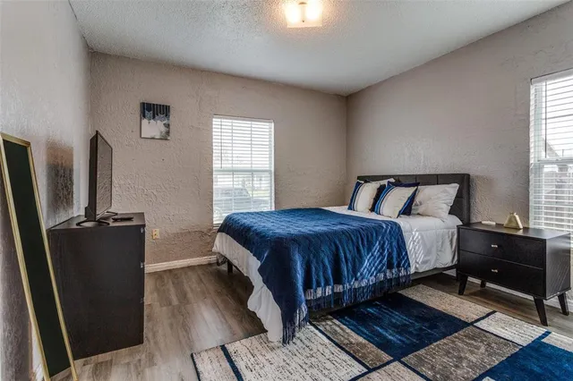 a bedroom with a bed rug and wooden floor