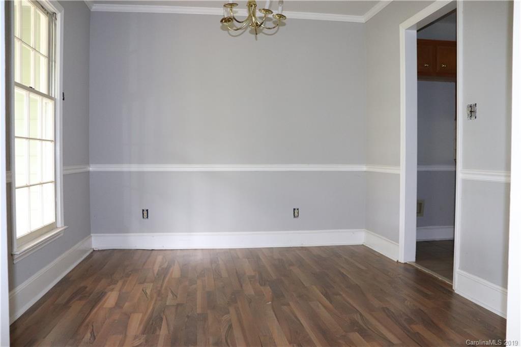 6520 Medlin Road Monroe, NC 28112 - Photo 9 of 22 an empty room with wooden floor and windows