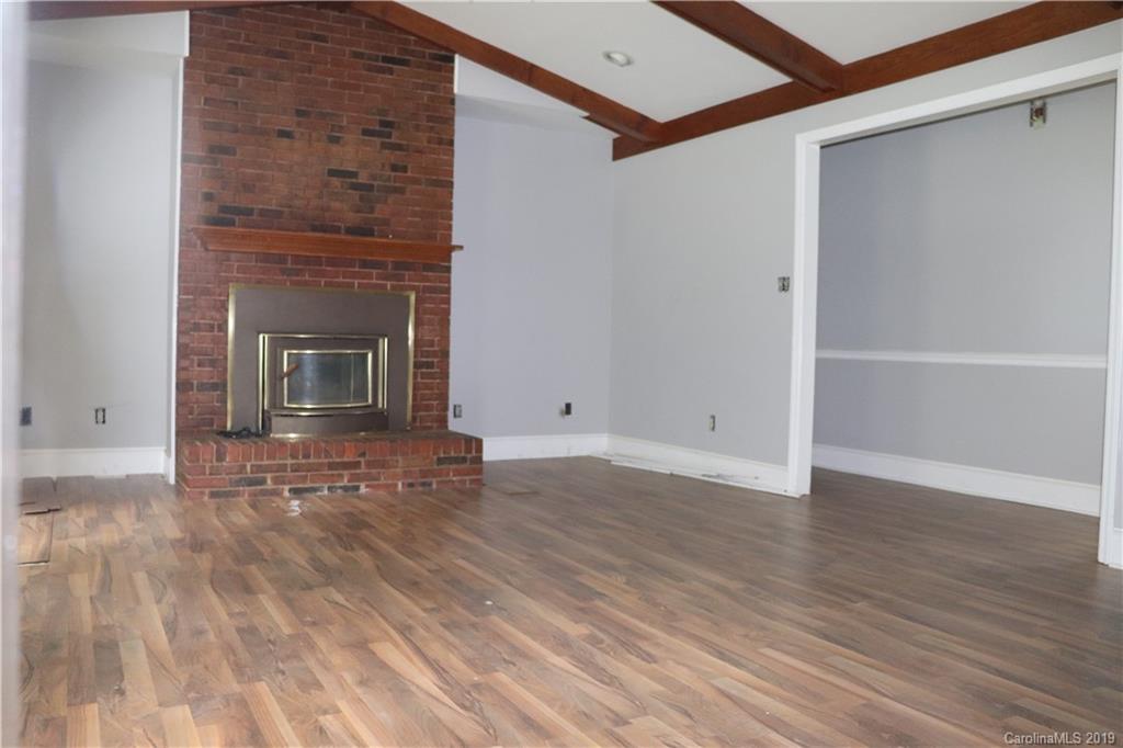 6520 Medlin Road Monroe, NC 28112 - Photo 10 of 22 a view of empty room with wooden floor and fireplace