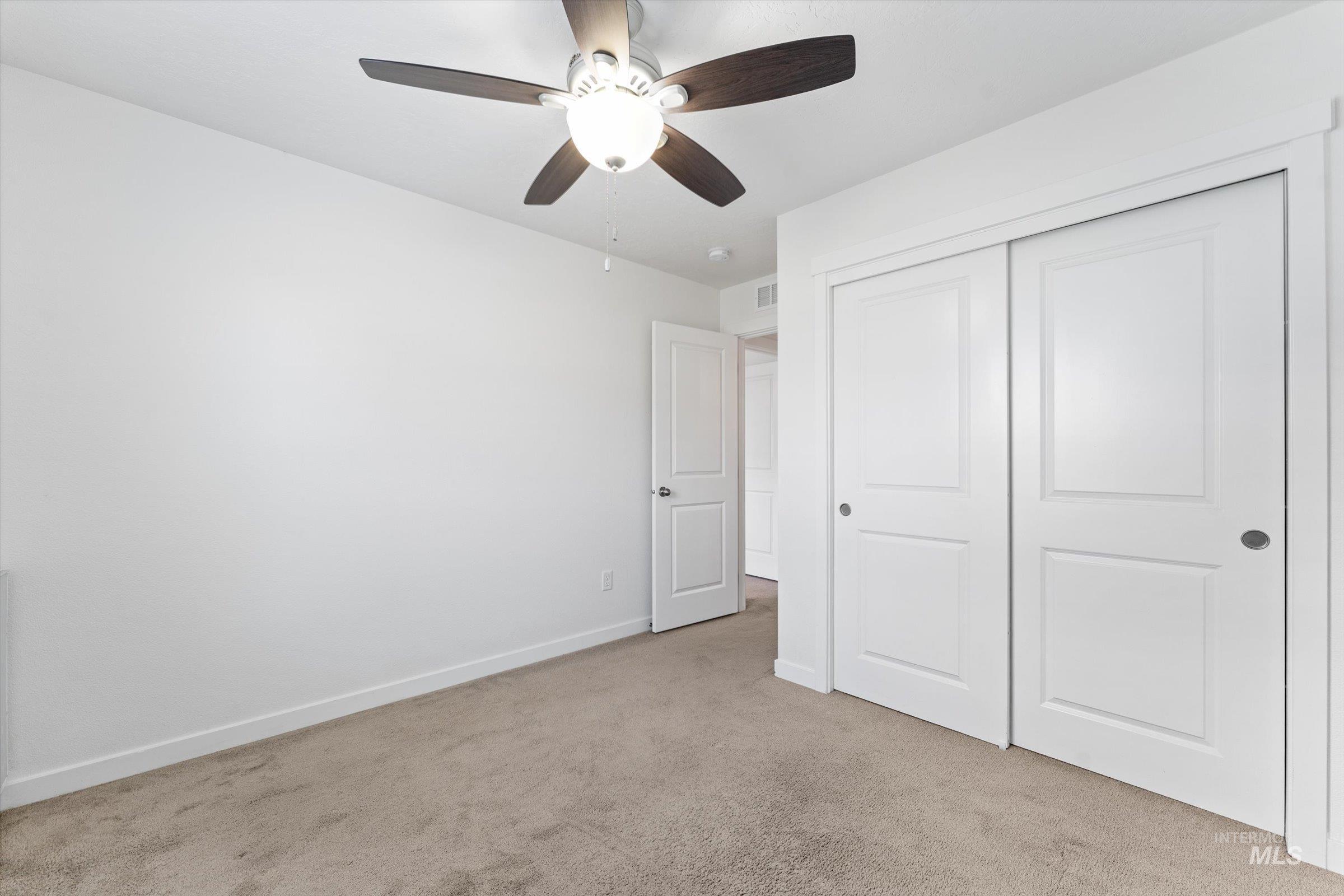 17798 Goose Ridge Avenue Nampa, ID 83687 - Photo 17 of 31 Unfurnished bedroom featuring light colored carpet, a ceiling fan, and a closet