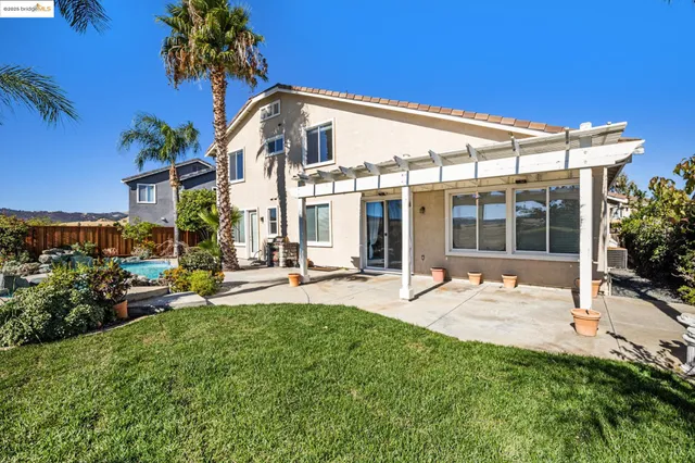a view of a backyard with couches under an umbrella