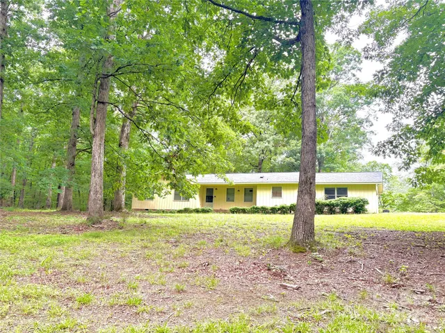 a view of a house with backyard from a big yard