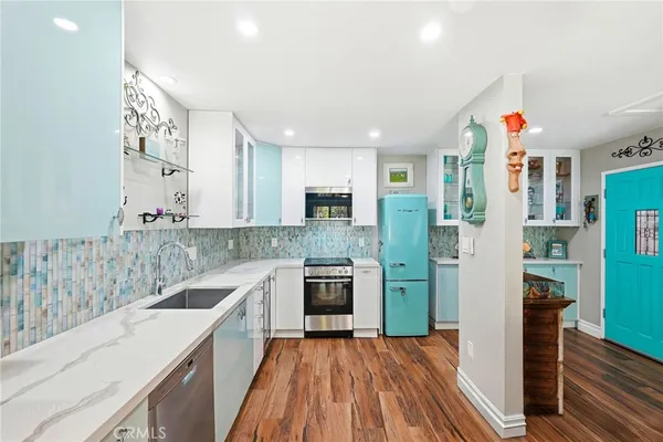 a kitchen with granite countertop a refrigerator stove top oven and sink