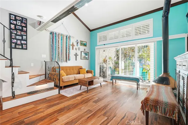 a living room with furniture large windows and wooden floor