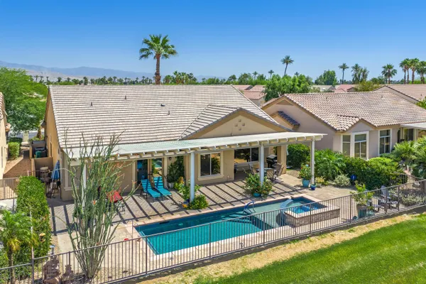an aerial view of a house with swimming pool and furniture